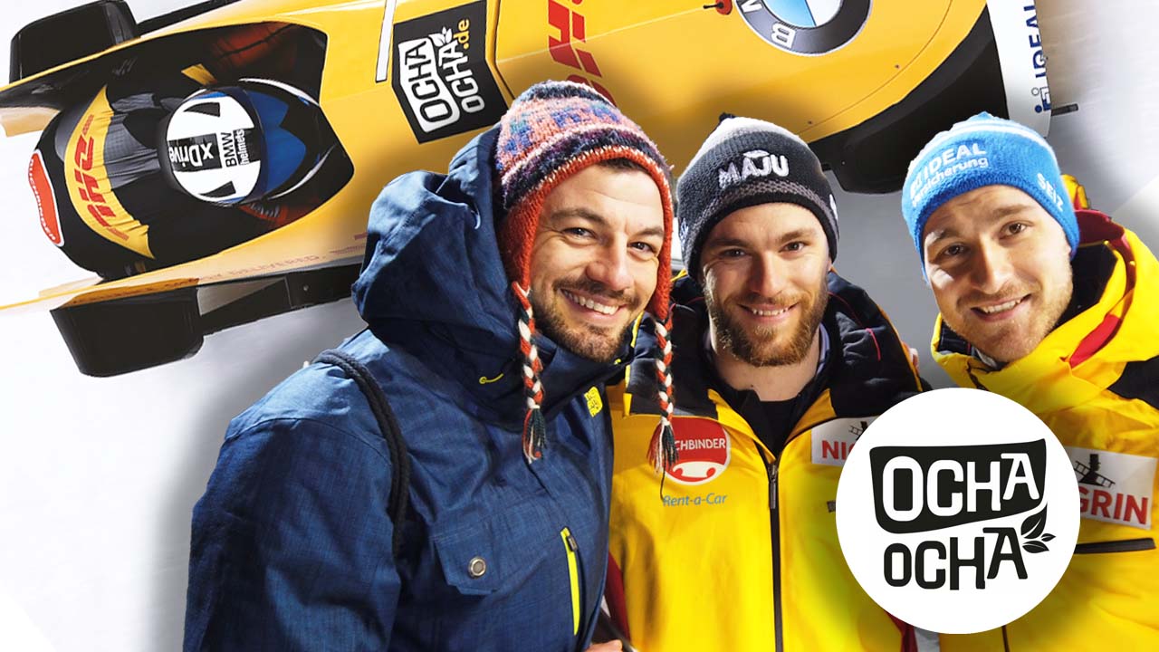 Das Foto zeigt Christopher Gogolin mit dem Bob-Team nach der Weltmeisterschaft am Königssee in Bayern. Im Hintergrund ist der Ocha-Ocha®-Bob.