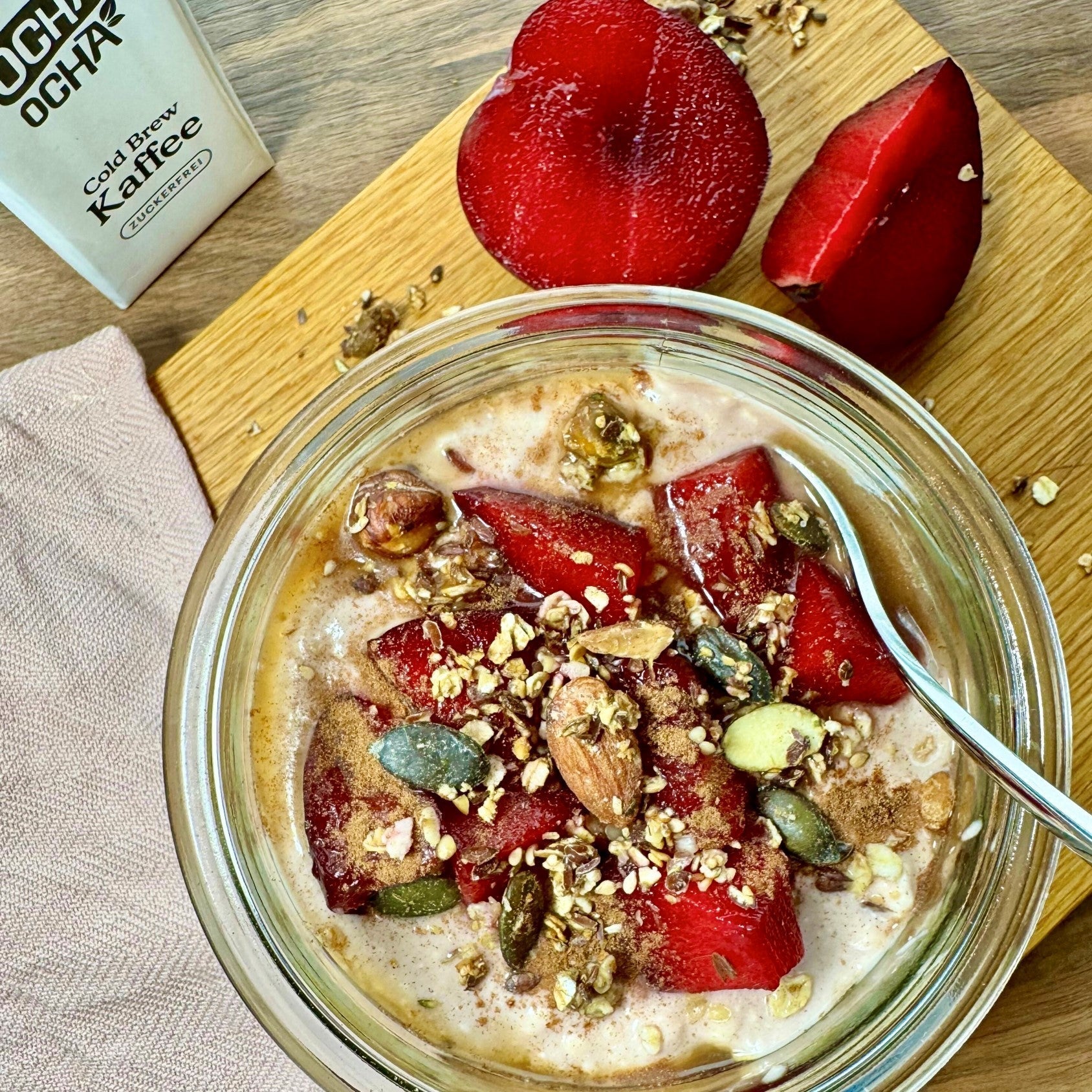 Rezept COLD BREW CINNAMON PLUM OATS in einer Glaschüssel auf einem Holzbrett